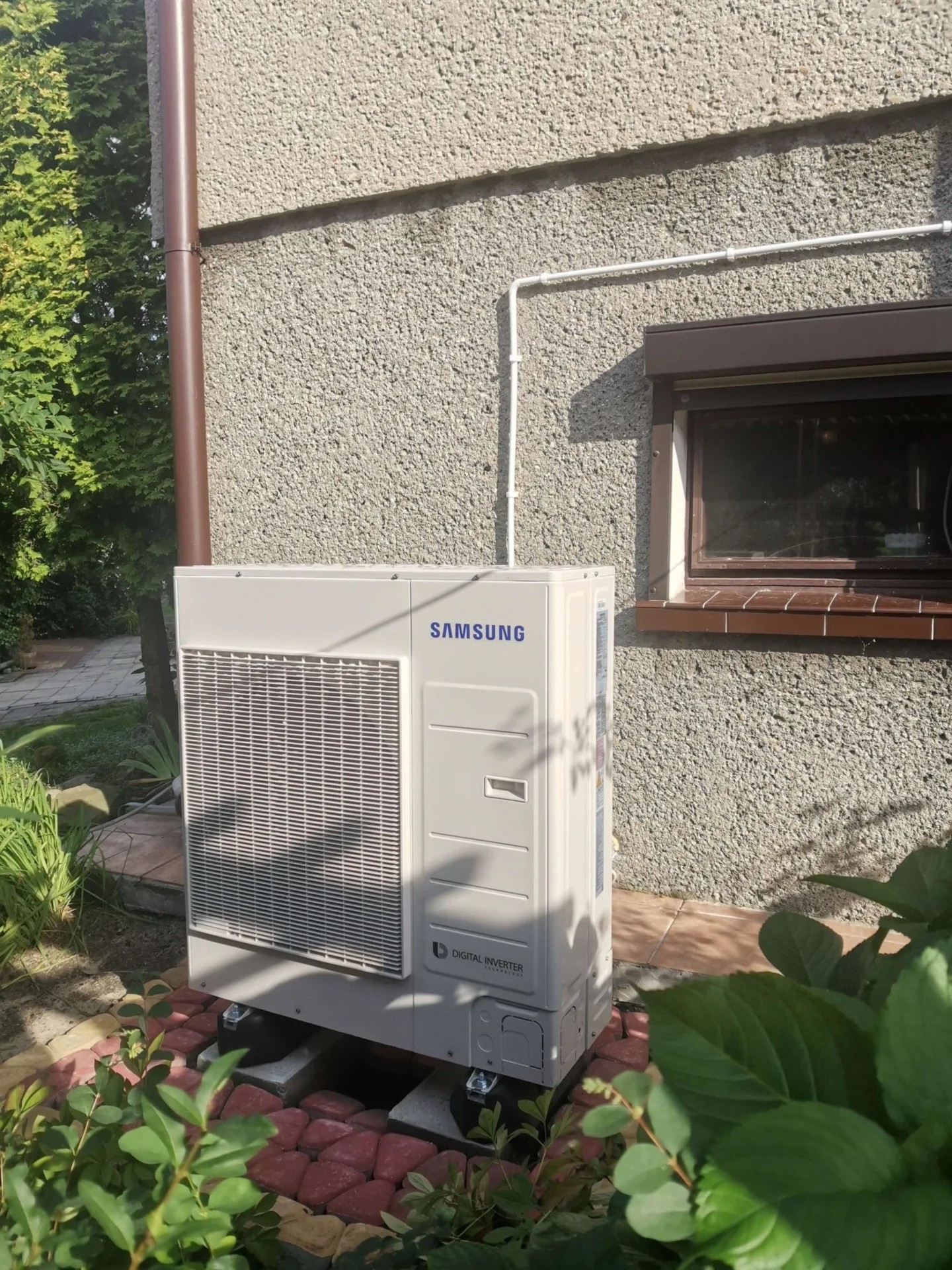 Fotografia Inter-Klima: jednostka zewnętrzna Samsung EHS na podstawach przy ścianie budynku w Zabrzu